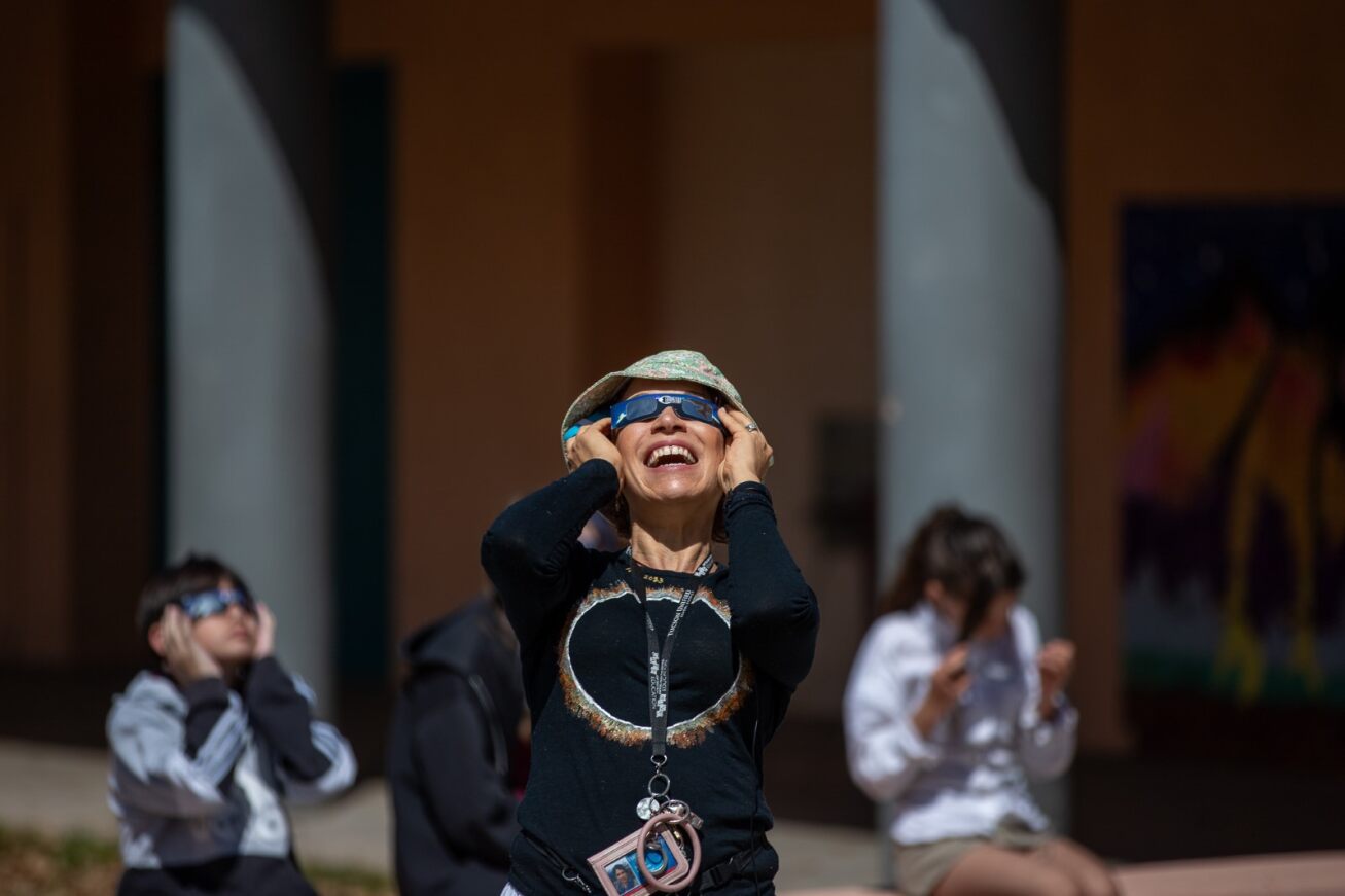 A Doolen teacher uses her special glasses to look at the eclipse