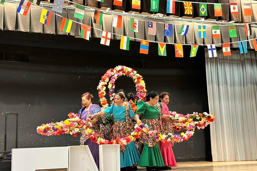 A group of women dance in colorful dresses