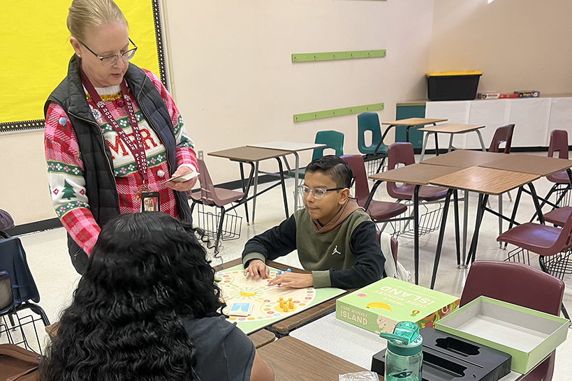 A teacher explains to her students how to play a game
