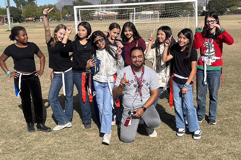 Students pose for a group photo on the soccer field