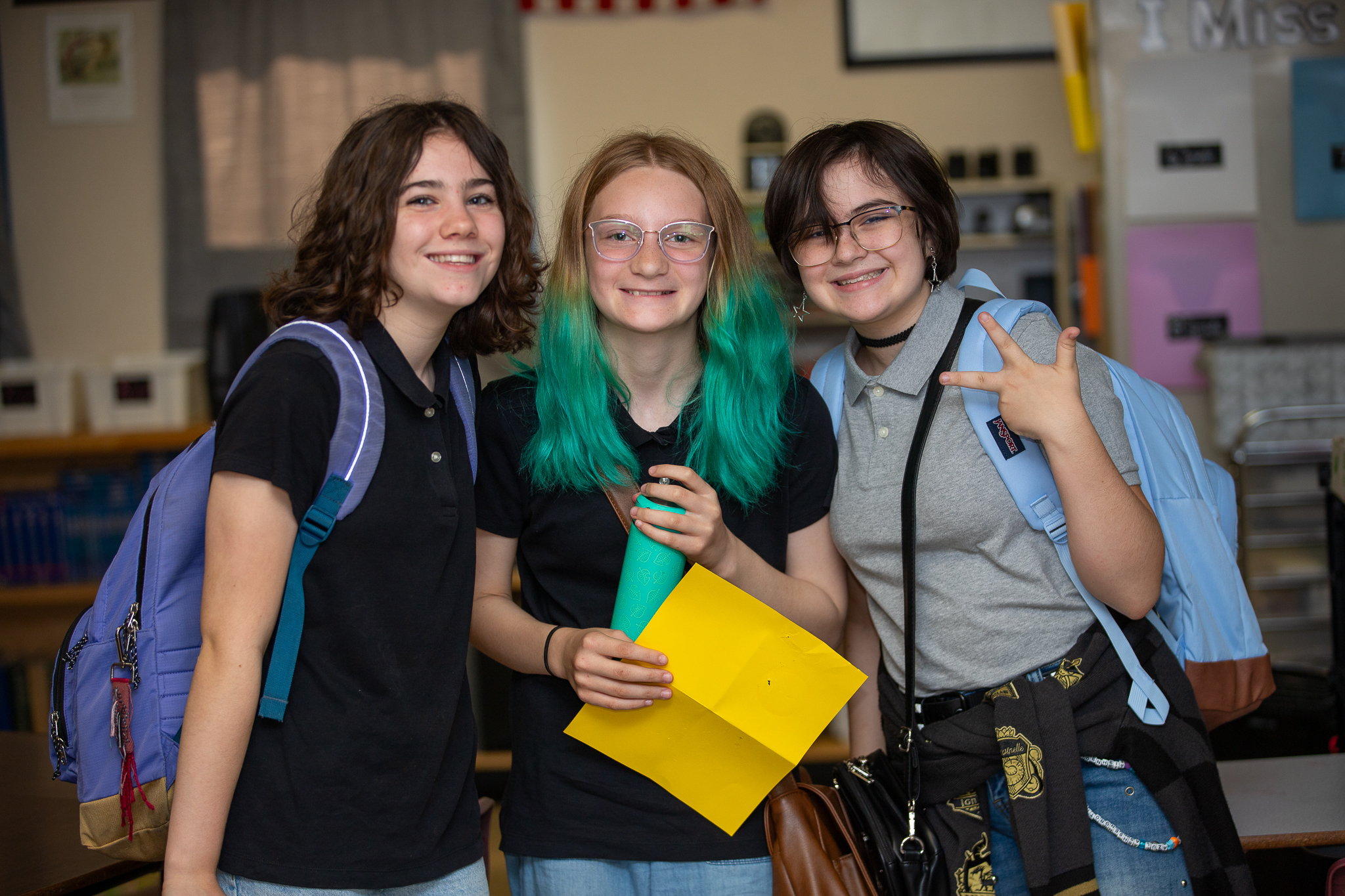 Three preteen girls smile together